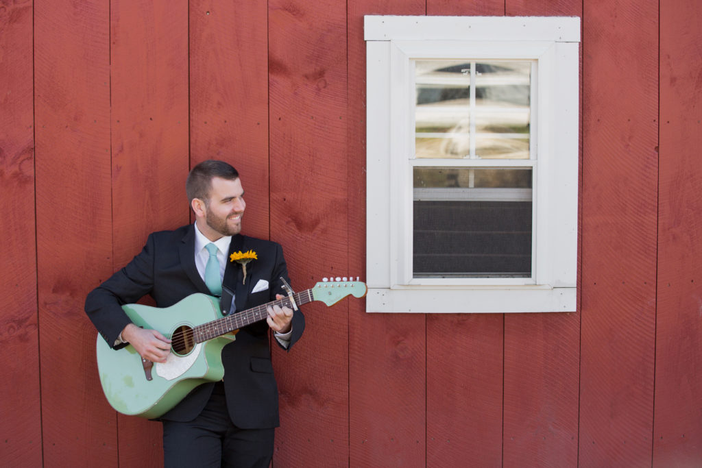 Groom plays the guitar at his rustic country wedding at the Five Bridge Inn in Rehoboth MA. 