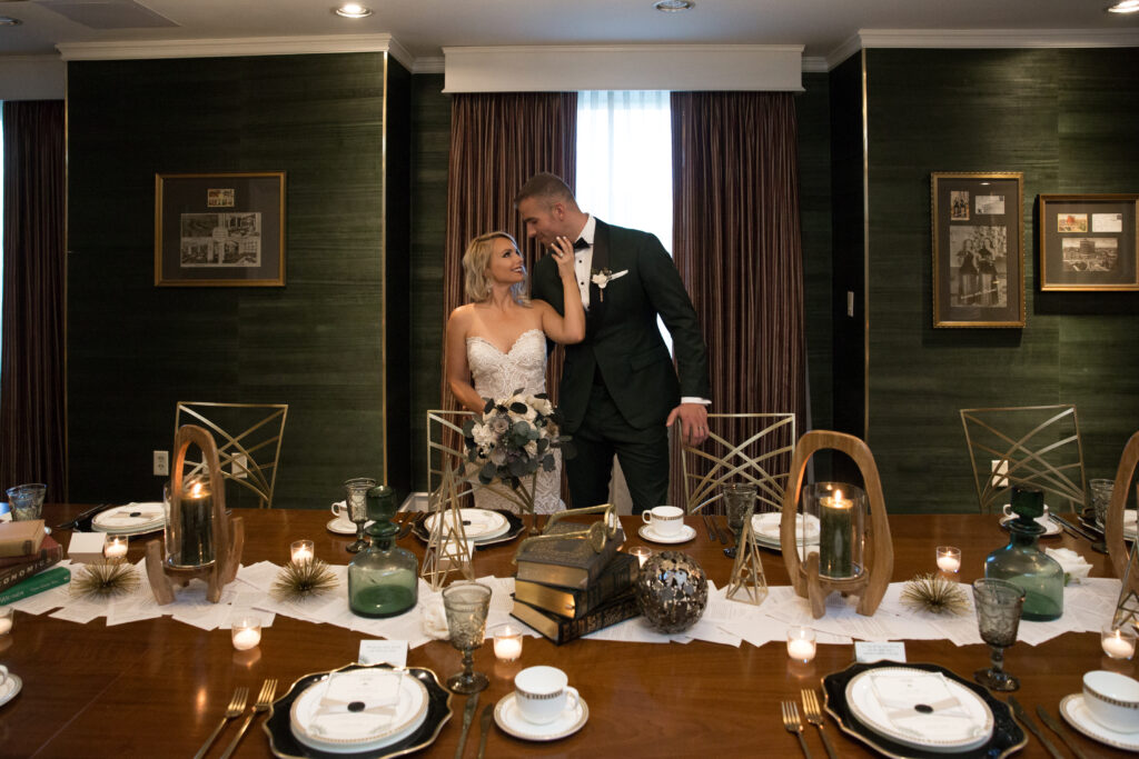A bride and Groom share a moment in the Graduate Boardroom. 