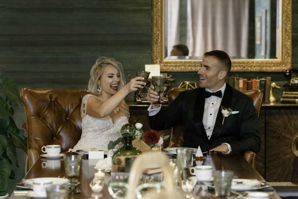 A bride and groom toast in the Graduate Boardroom. 