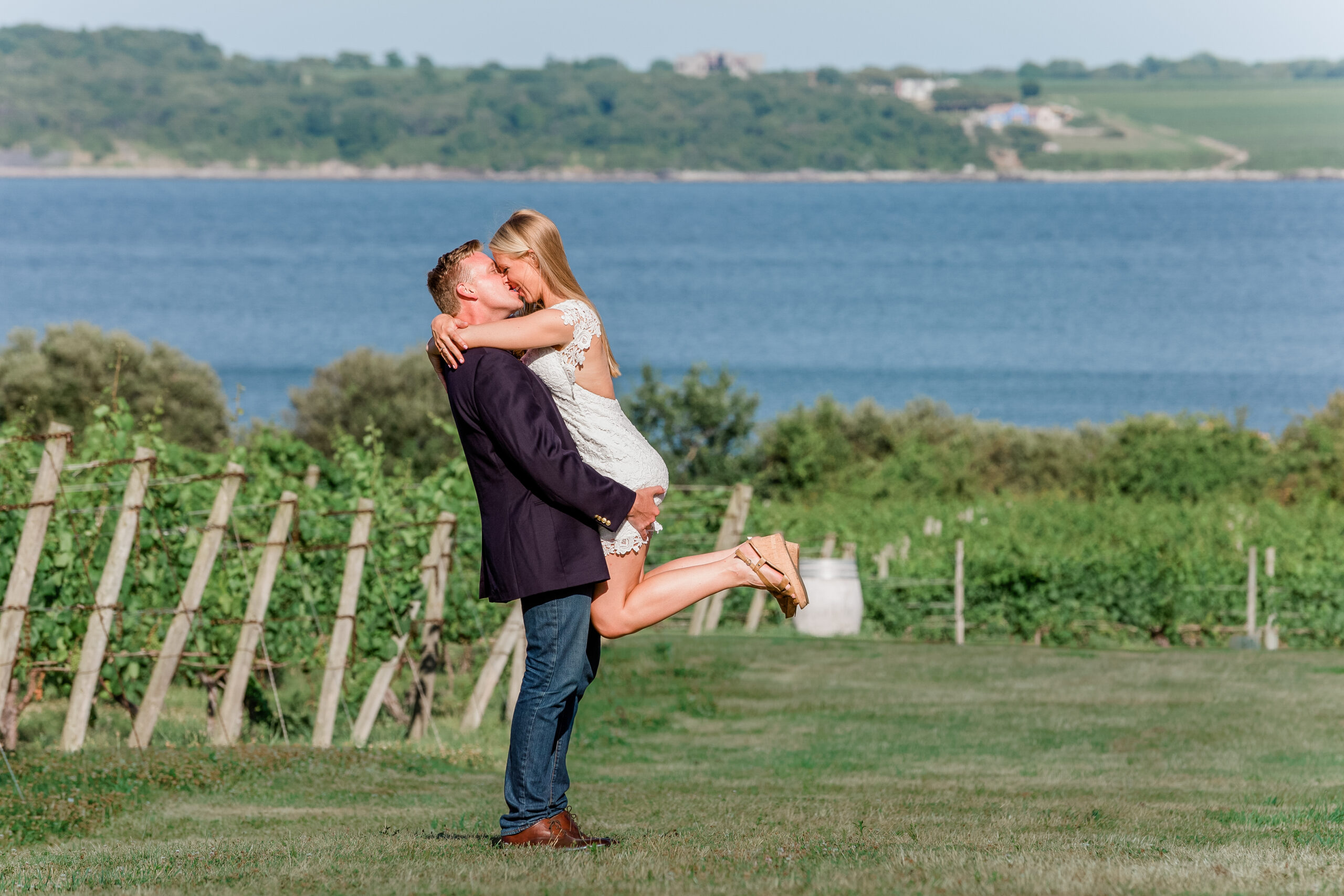 A bride and groom kiss on the grounds of Greenvale Vineyards overlooking the Sakonnet River.