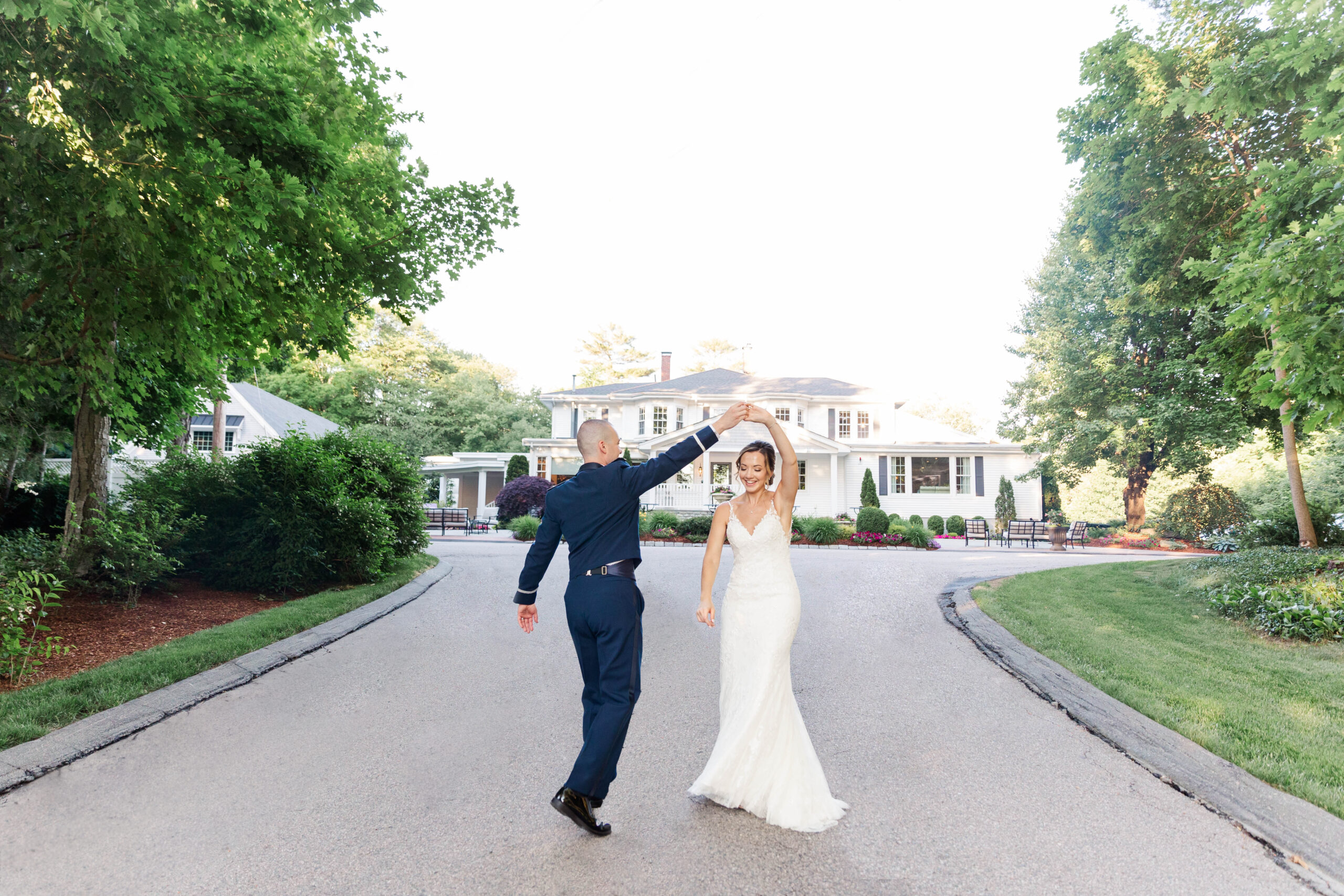 A groom twirls his bride in the driveway leading to Saphire Estate in Sharon. 