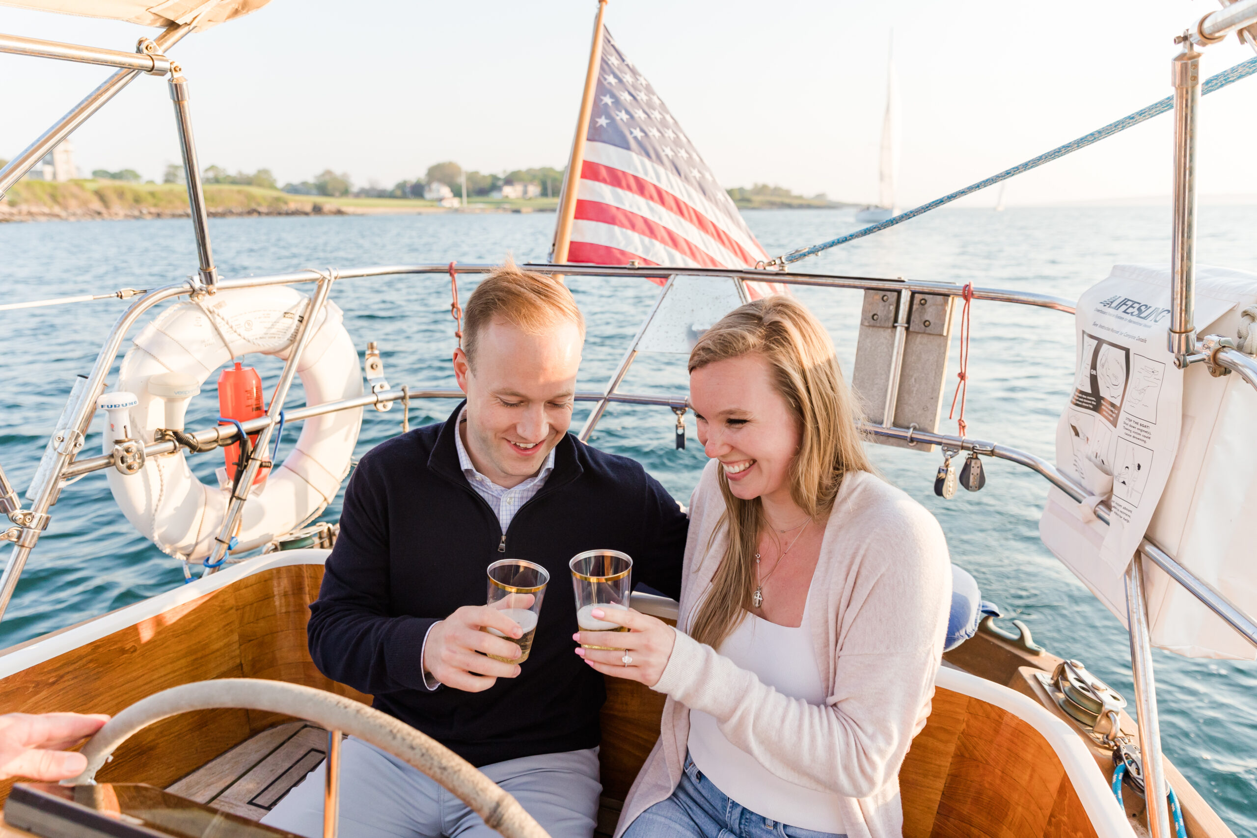 A couple toasts to their engagement aboard a sailboat.