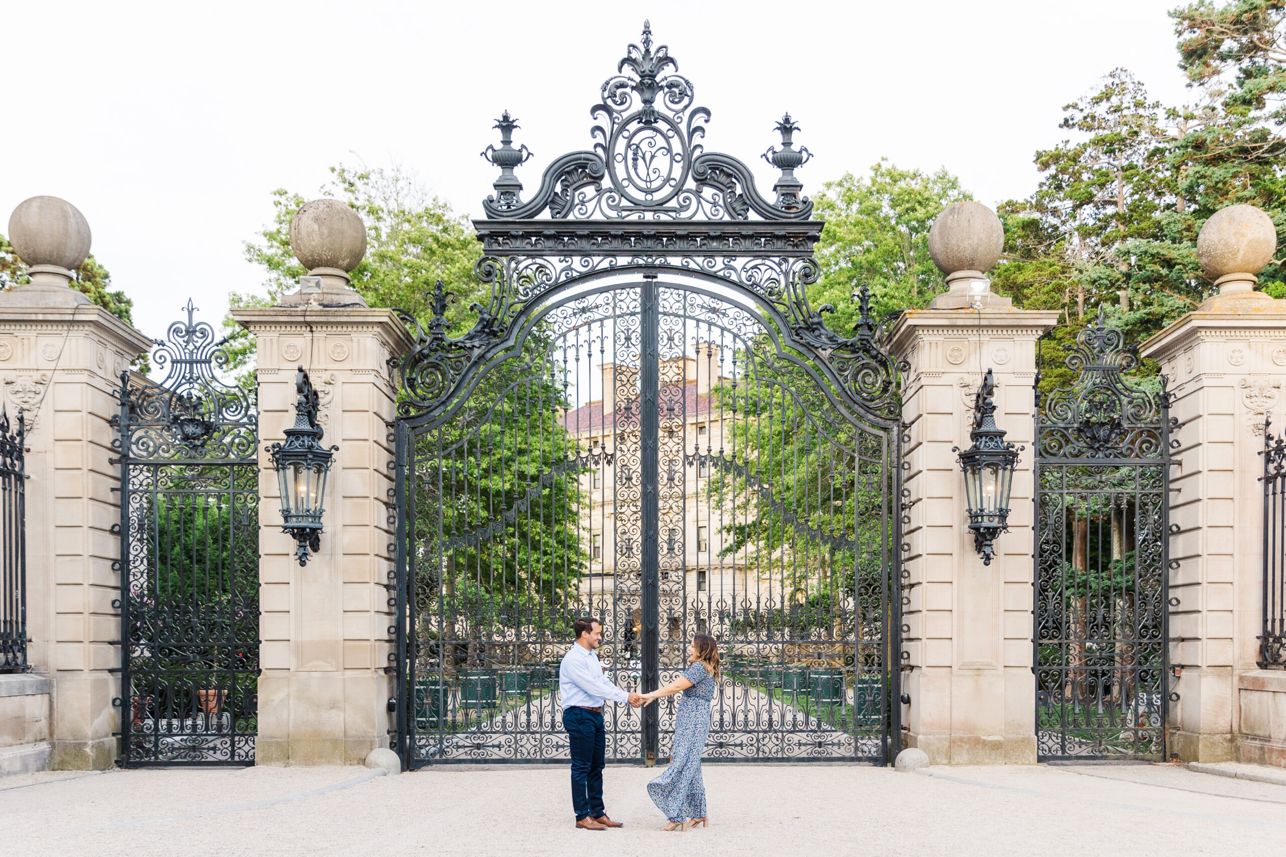 A couple dances infant of the oversized gates of the Breaker's Newport Mansion